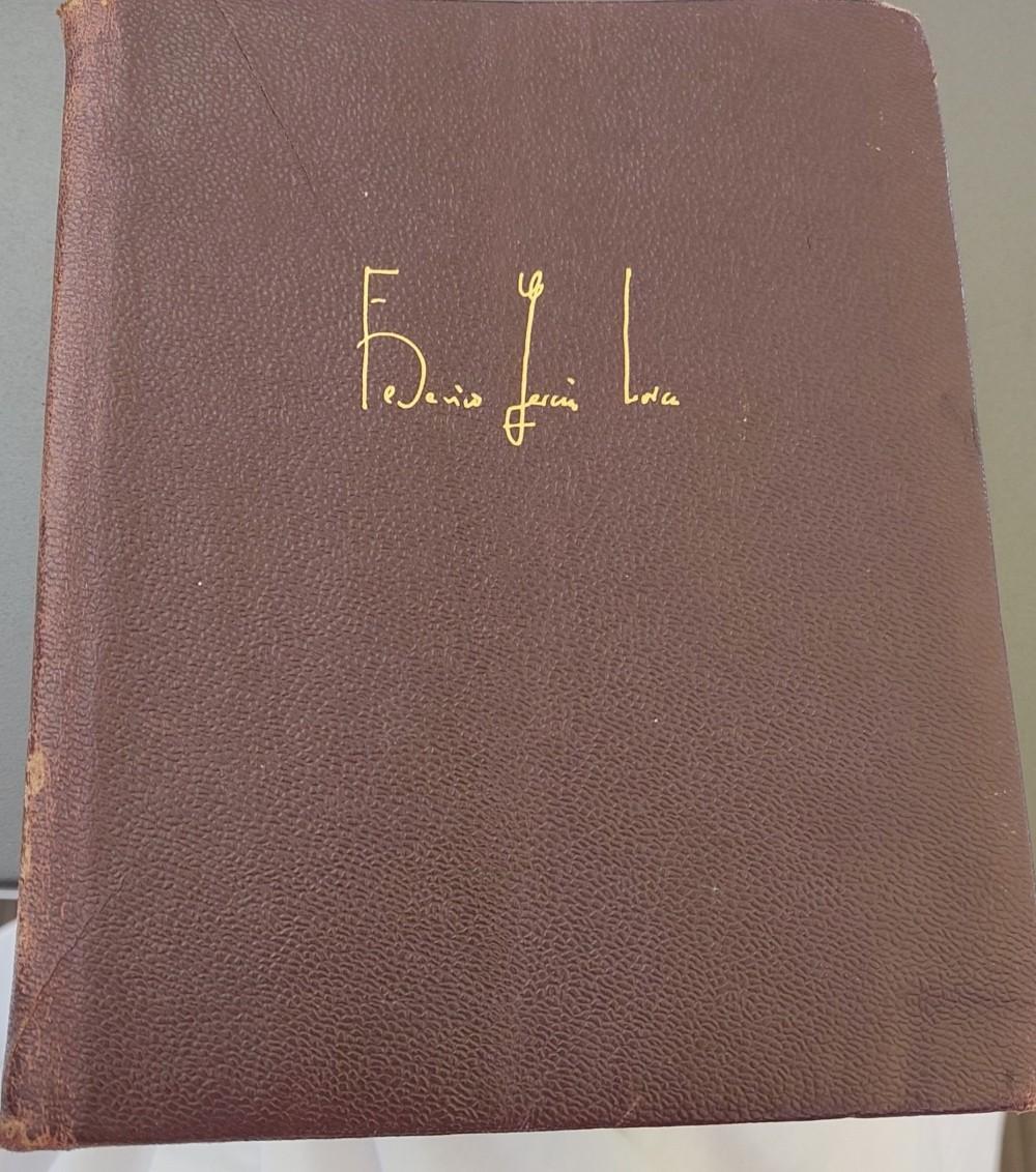 La tapa de un libro, de color rojo muy oscuro, con la firma de Federico García Lorca en letras doradas